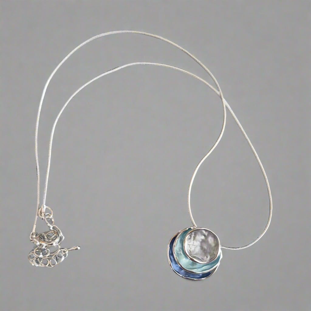 Silver necklace with a pendant on a gray background