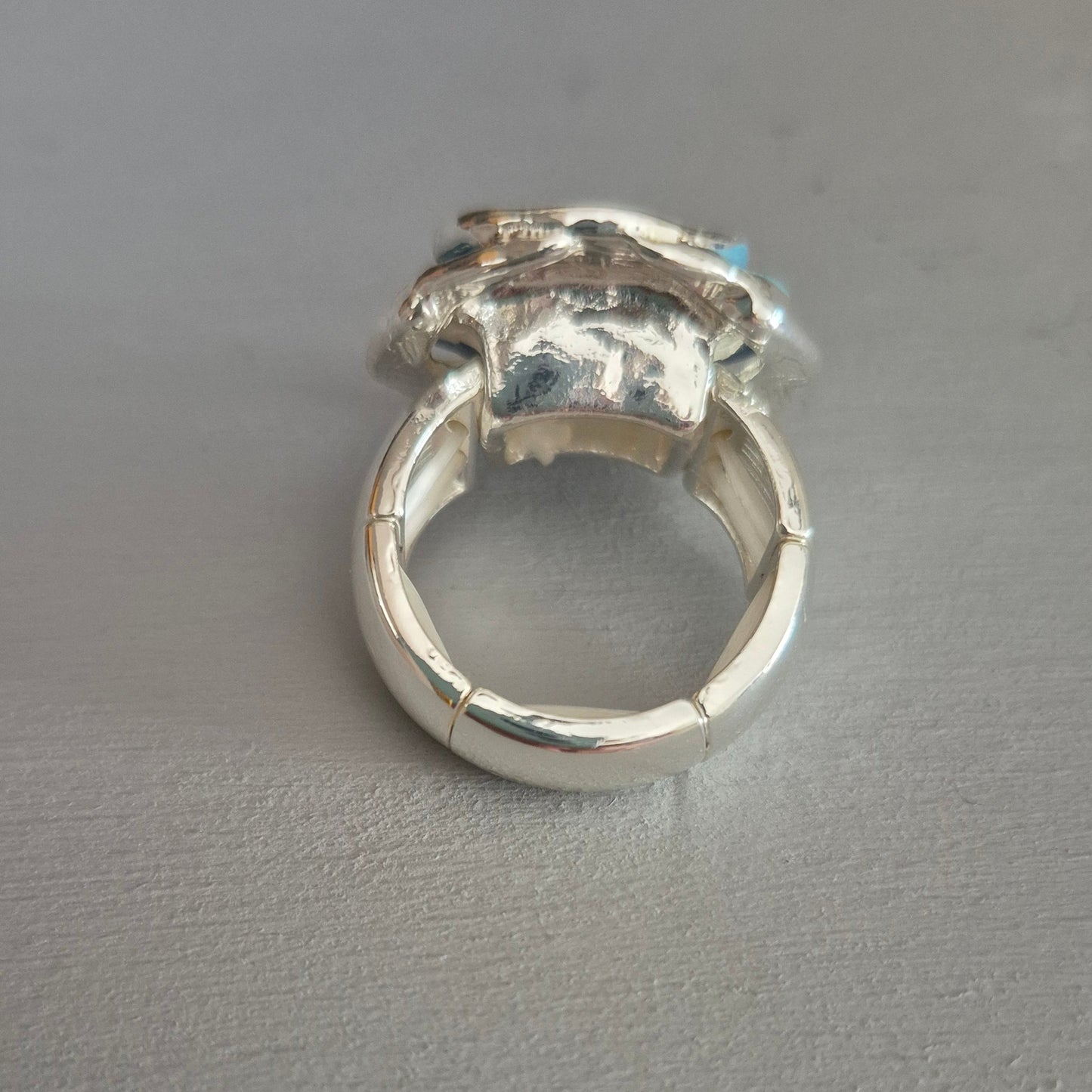 Silver ring with a diamond on a gray background