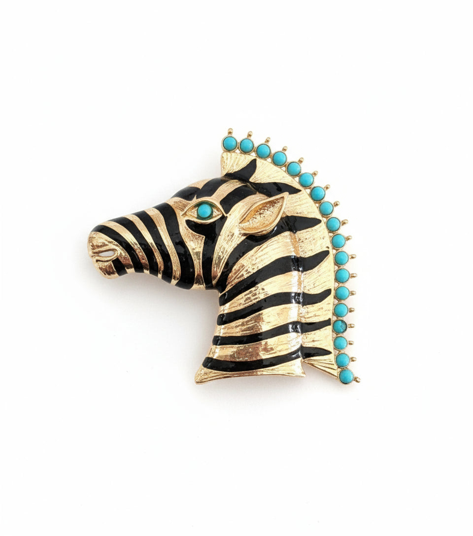 Zebra head brooch with turquoise stones on a gray background