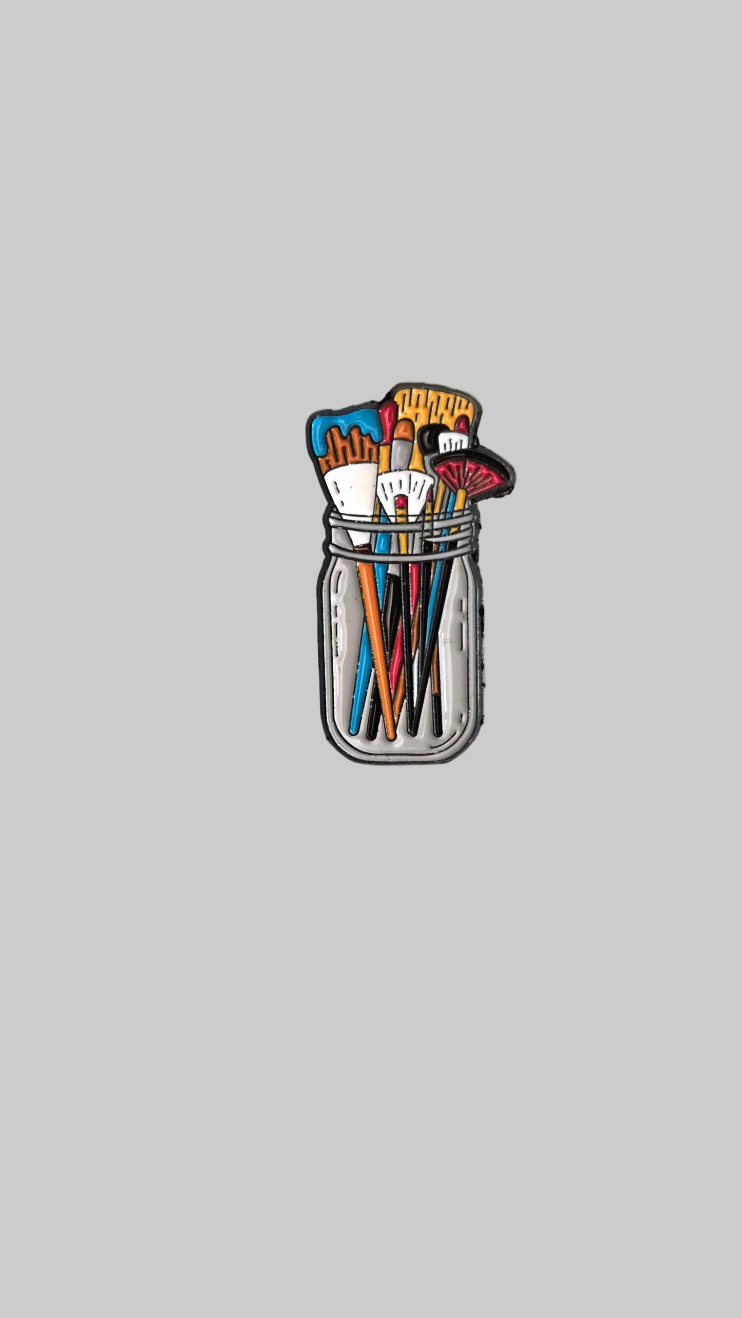 Patch of paintbrushes in a jar on a gray background