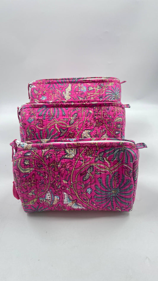 Set of three pink patterned pouches on a white background