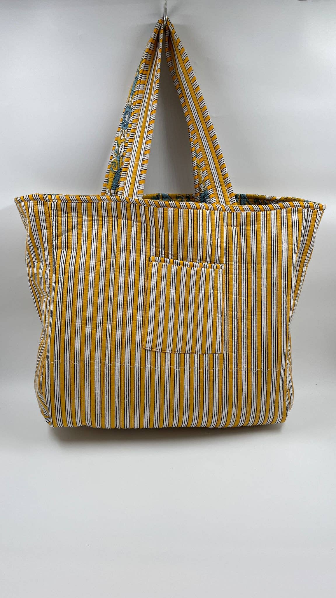 Yellow and white striped tote bag with a pocket on a white background